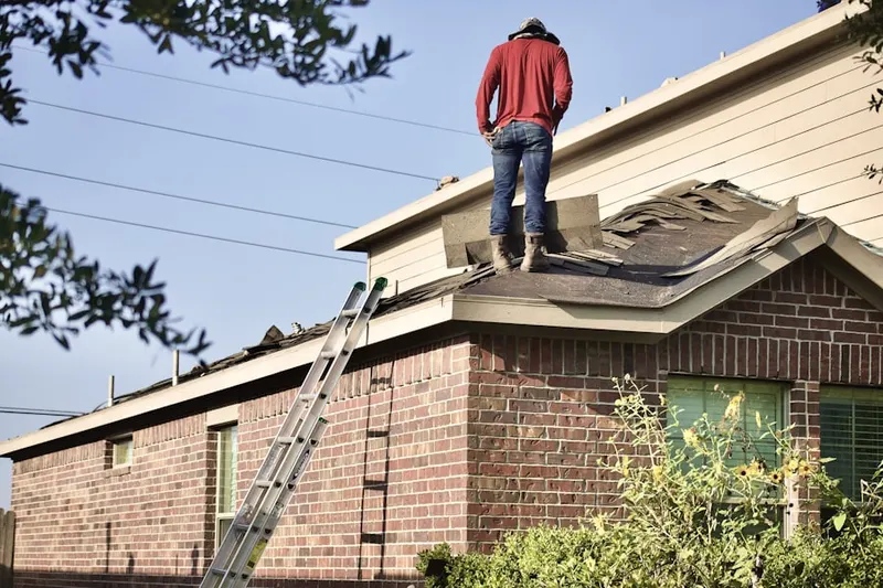Professional roofer working on a residential roof in Foot of Ten